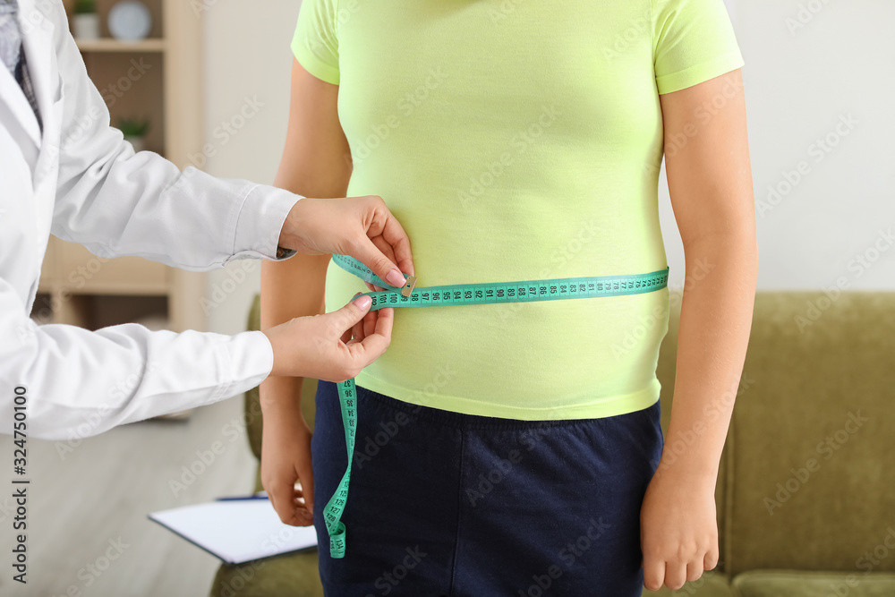 Doctor examining fat boy in clinic