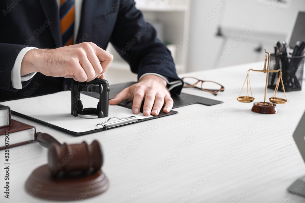 Male lawyer with stamp and document in office