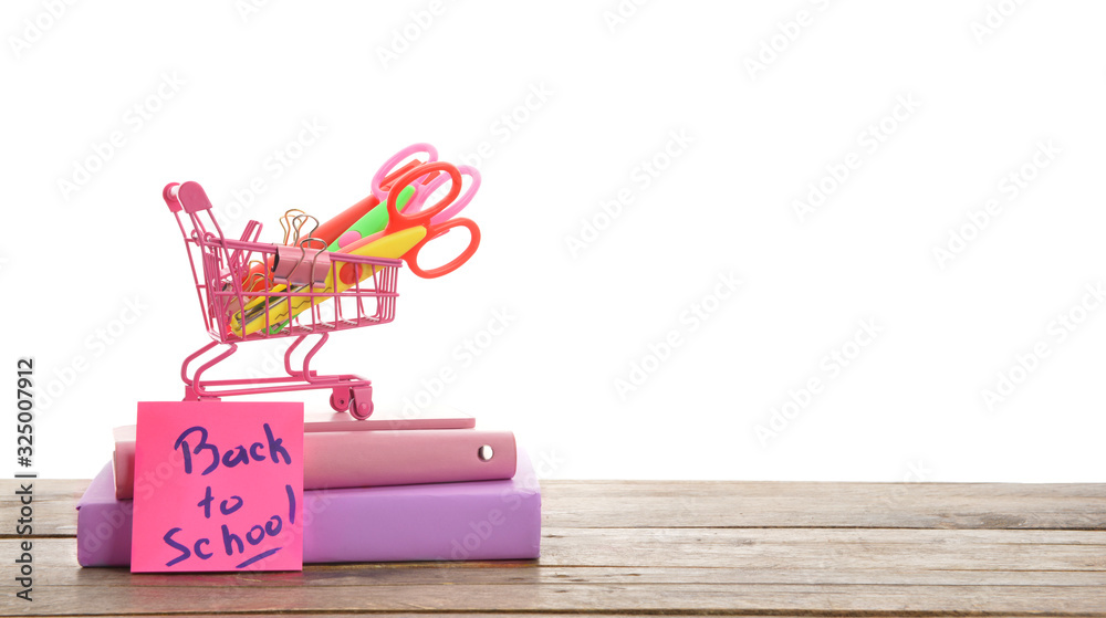 Set of school supplies and shopping cart on table against white background