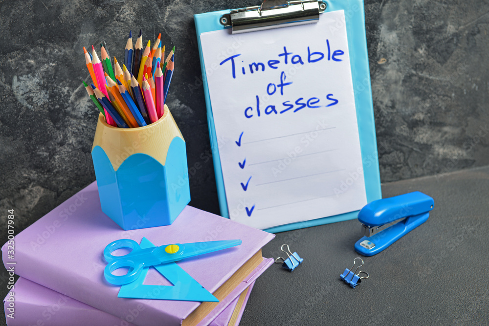 Set of school supplies and timetable on table