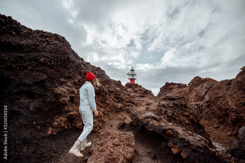 Carefree stylish woman enjoying trip on a rocky landscapes, walking on the desert pathway near a Ten