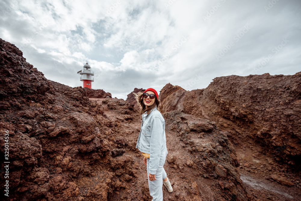 Carefree stylish woman enjoying trip on a rocky landscapes, walking on the desert pathway near a Ten