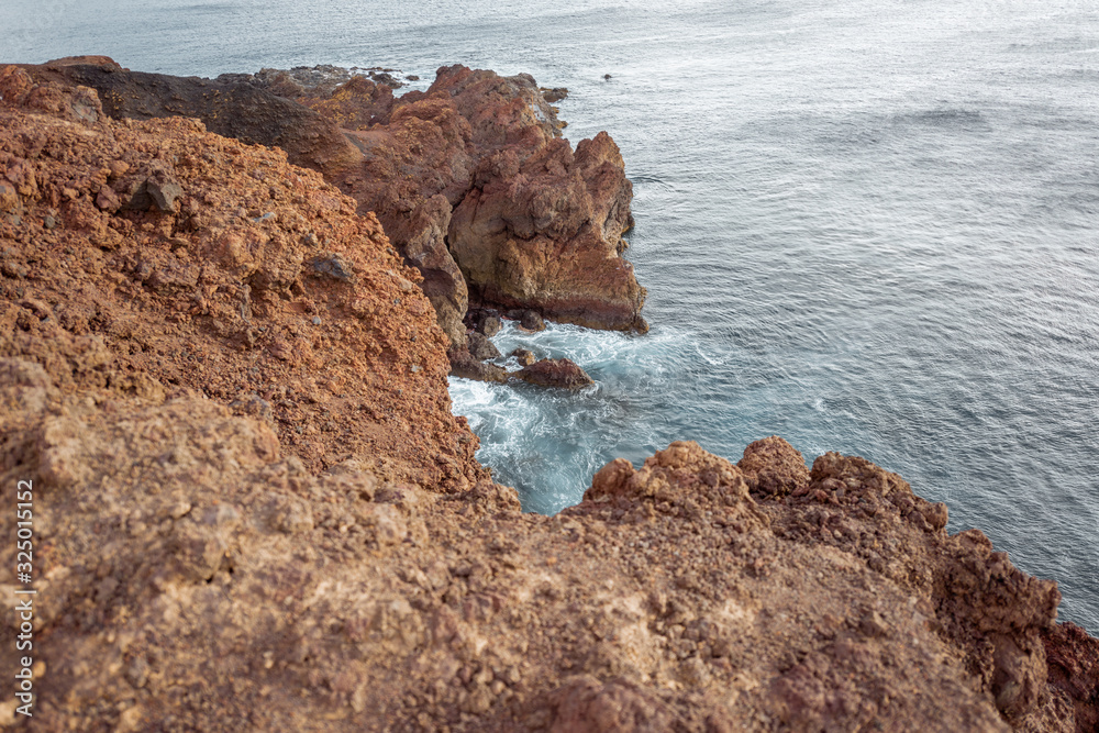 Top view on the steep precipice on rocky coast