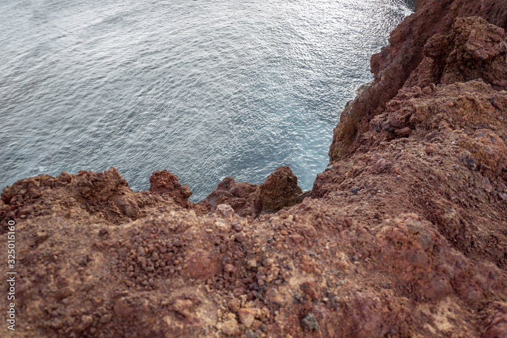 Top view on the steep precipice on rocky coast