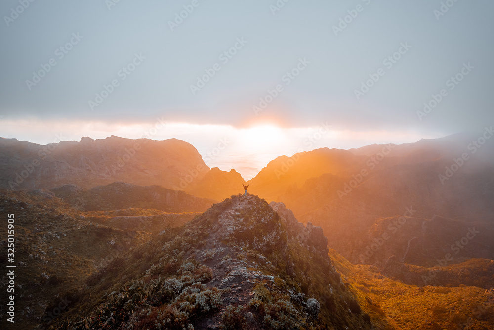 Breathtaking scenery on the mountain range under the clouds and ocean on the background during a sun