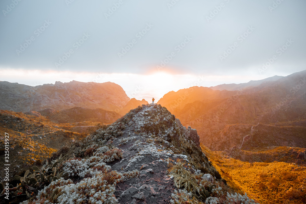 Breathtaking scenery on the mountain range under the clouds and ocean on the background during a sun