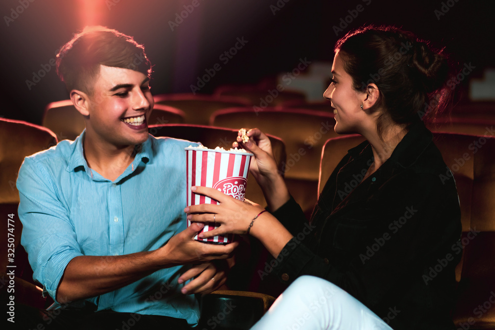 Man and woman watching movie in the movie theater cinema. Group recreation activity and entertainmen