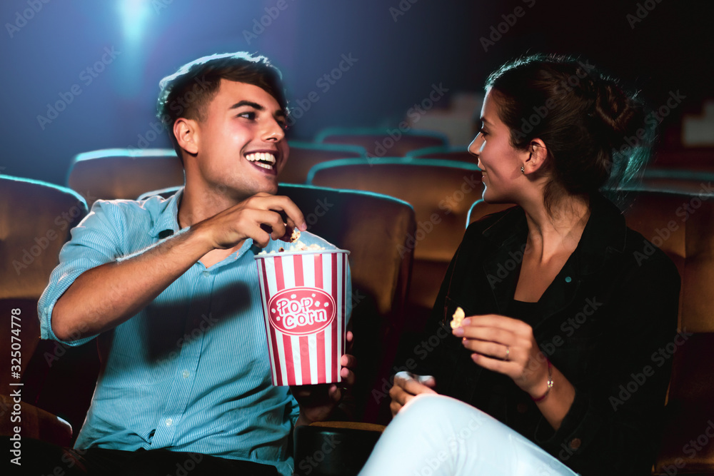 Man and woman watching movie in the movie theater cinema. Group recreation activity and entertainmen