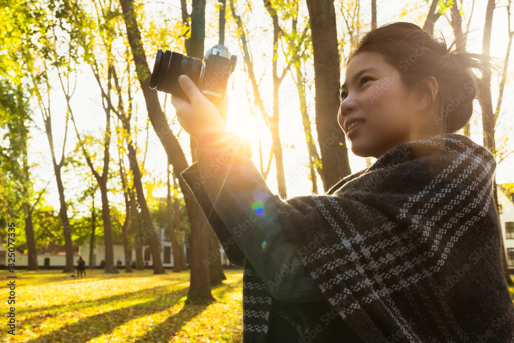 特写亚洲女性手持复古相机旅行者，背景为古老的传统建筑，a