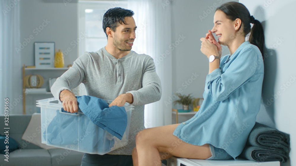 Beautiful Young Couple Talking in a Living Room at Home. Girl is Sitting on a Washing Machine, Man H