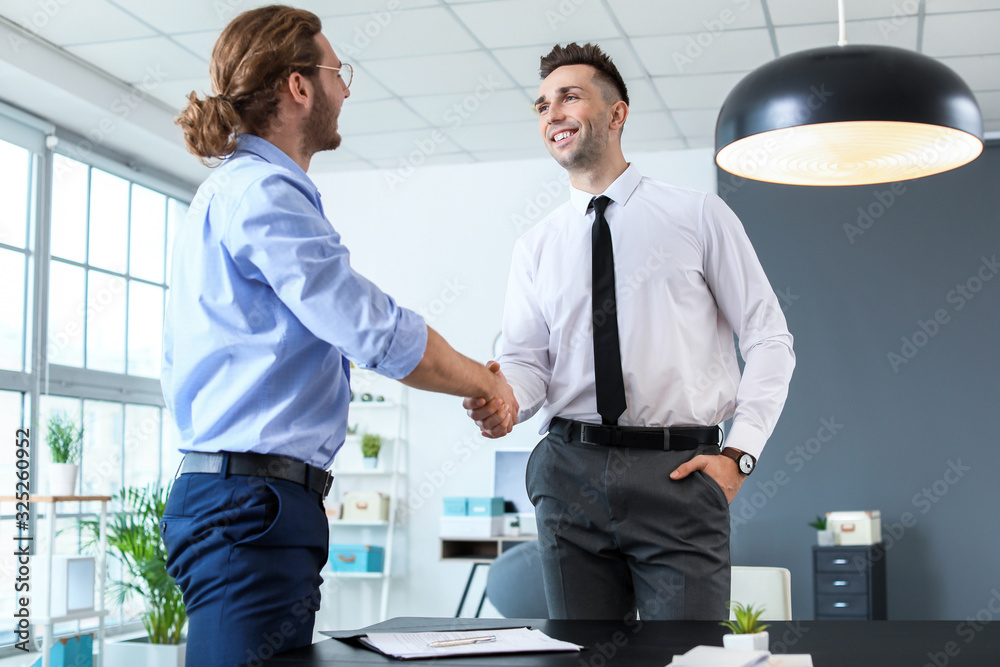 Human resources manager shaking hands with applicant after successful interview