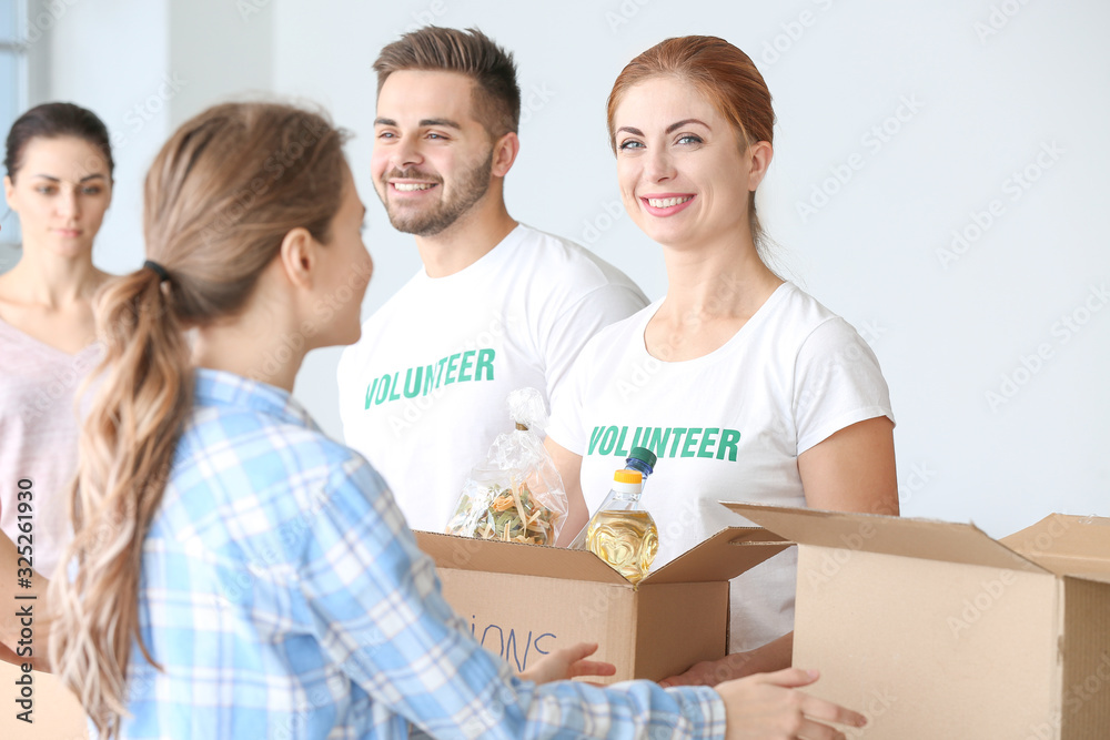 Team of volunteers giving products to poor people