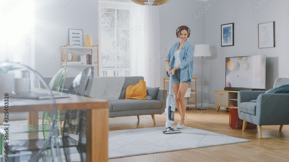 Young Beautiful Woman in Jeans Shirt and Shorts is Listening to Music on Her Headpones, Dancing and 