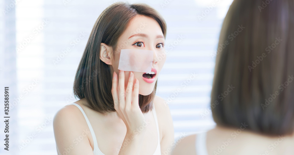 woman use oil blotting paper