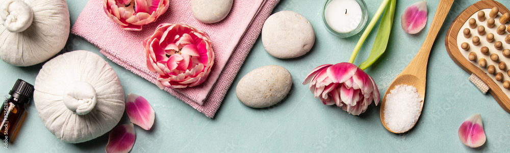 Flat lay of spa treatment set with pink flowers