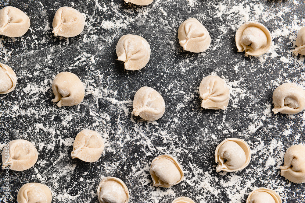 Raw fresh dumplings on dark background