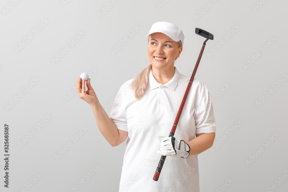 Sporty mature golfer on light background