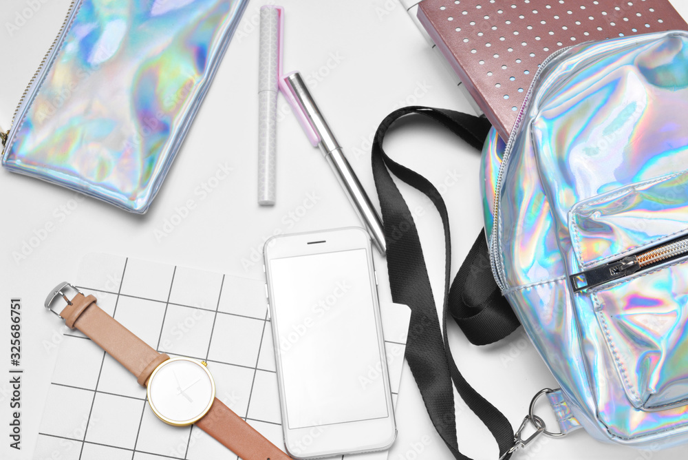 Set of school supplies with backpack and mobile phone on white background