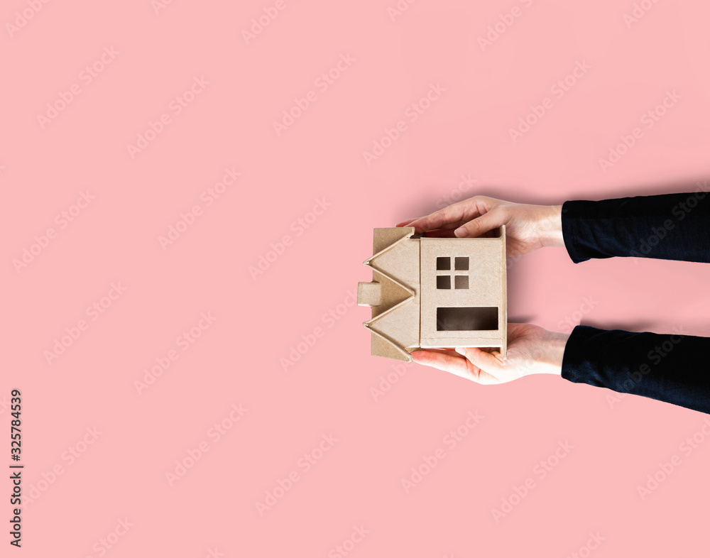 Woman holding a cardboard house overhead view