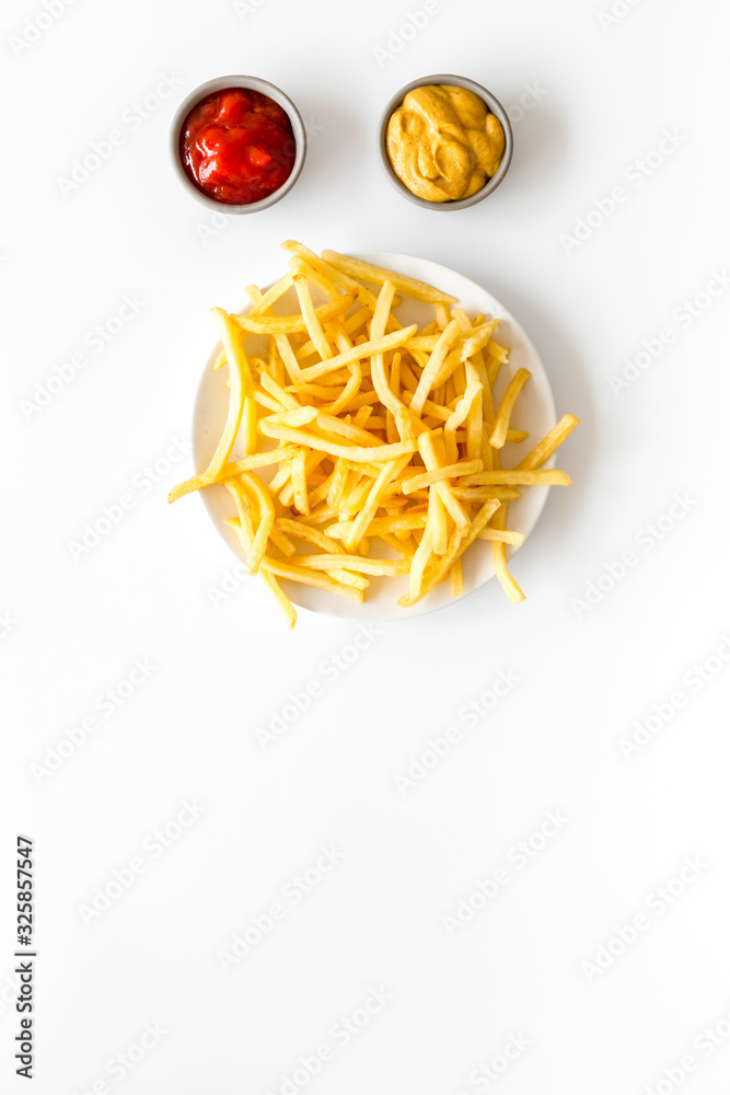 Fast food symbol. French fries on plate on white table top-down copy space