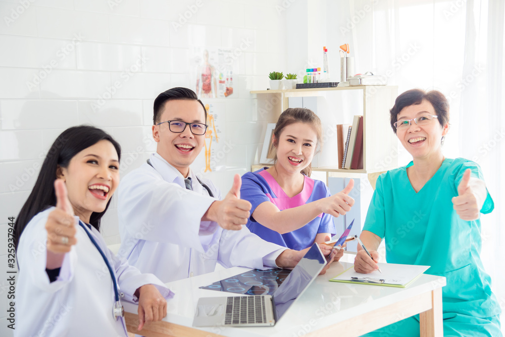 Group of asian medical team sitting together and showing thumb up with smile at camera in conference