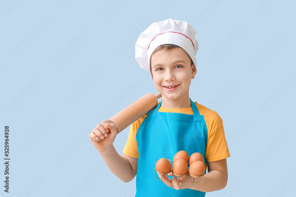 Cute little chef on color background