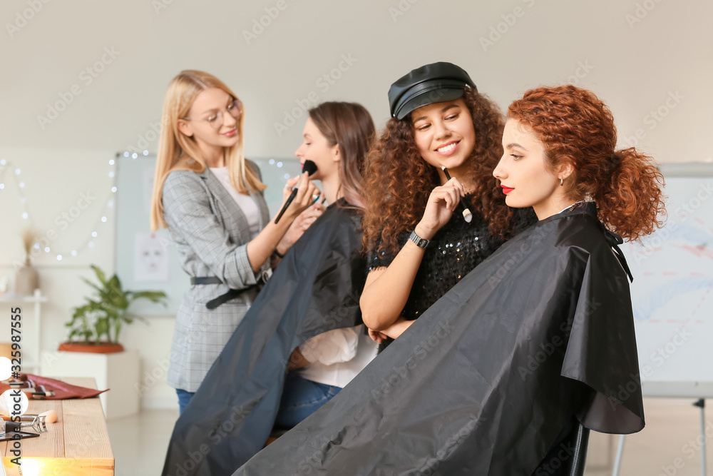 Young woman with model in makeup school