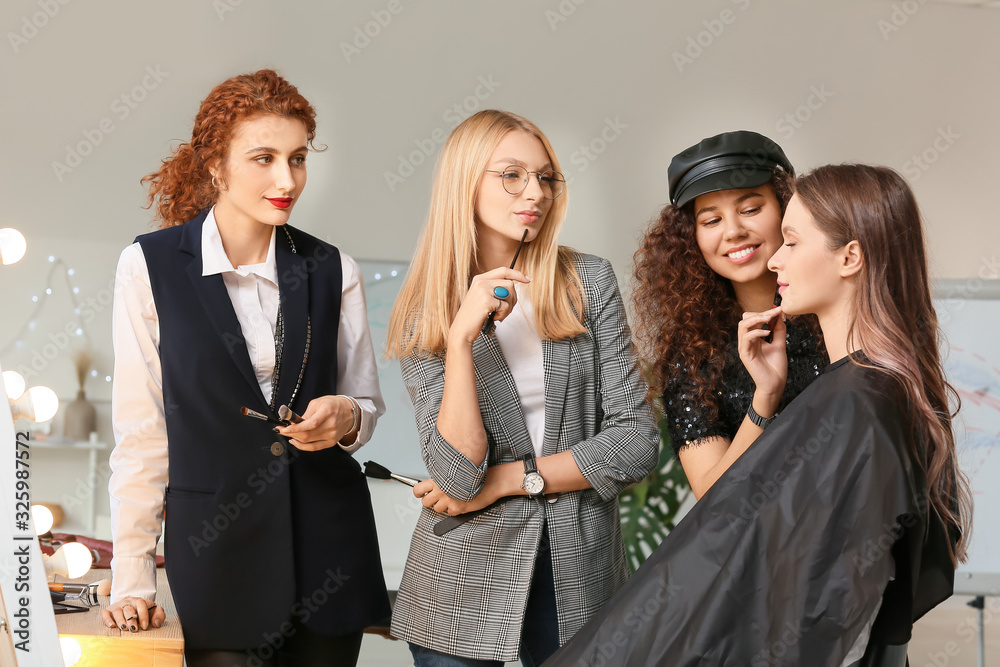 Young woman teaching students in makeup school