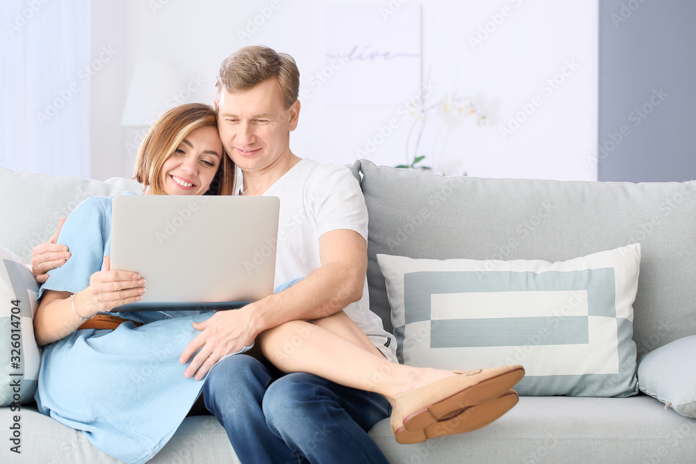 Beautiful couple with laptop at home