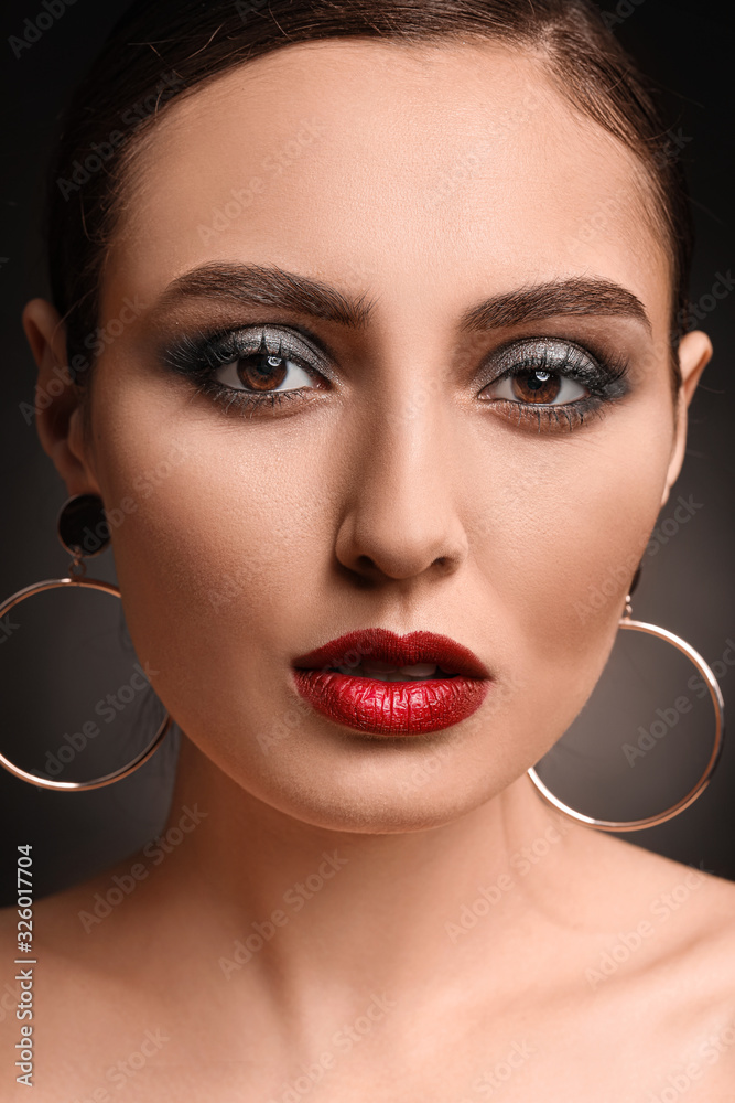 Young woman with beautiful makeup on dark background