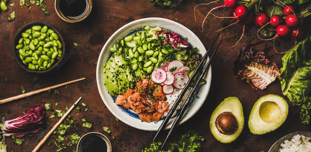 Healthy lunch, dinner. Flat-lay of salmon poke bowl or sushi bowl with vegetables, greens, sushi ric