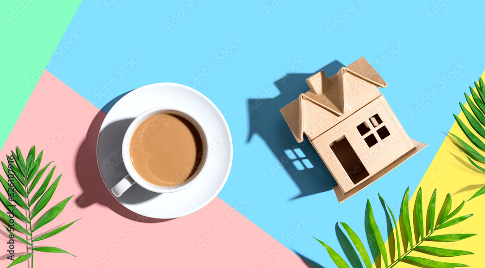 Cardboard house with a cup of coffee - flat lay