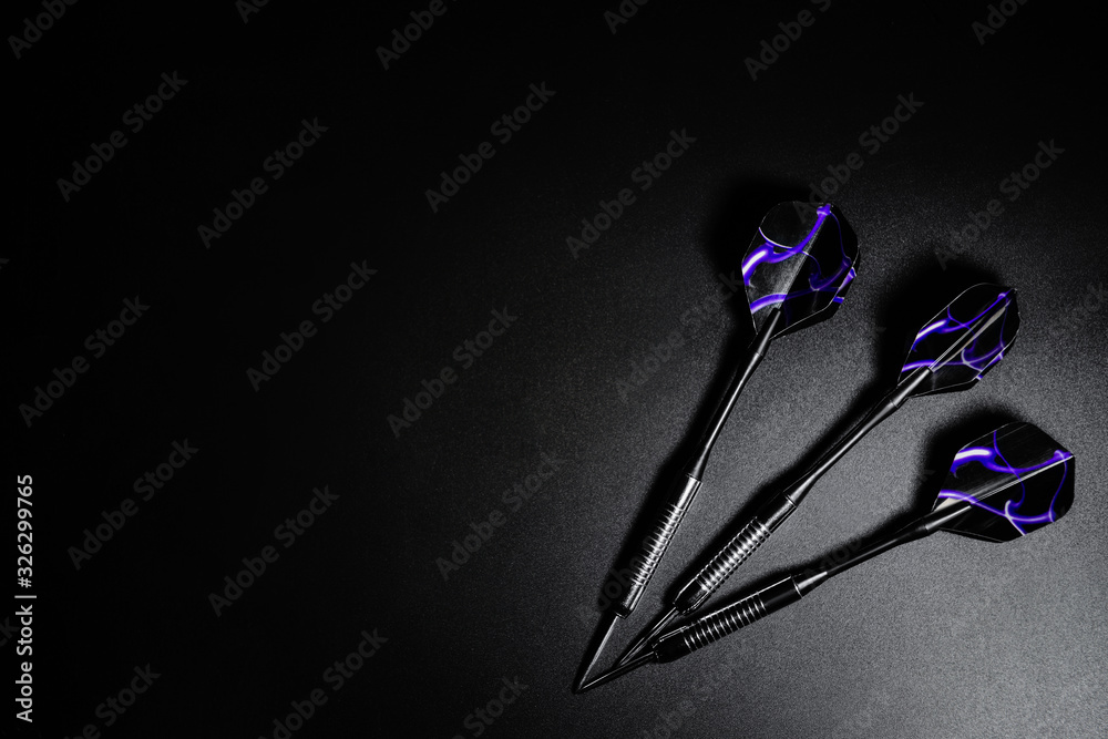 Darts on dark background, top view