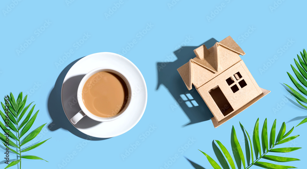 Cardboard house with a cup of coffee - flat lay