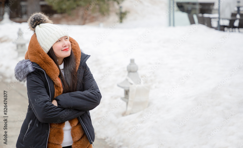 An Asian woman and her family are enjoying a winter snowy vacation and doing family activities in Ze