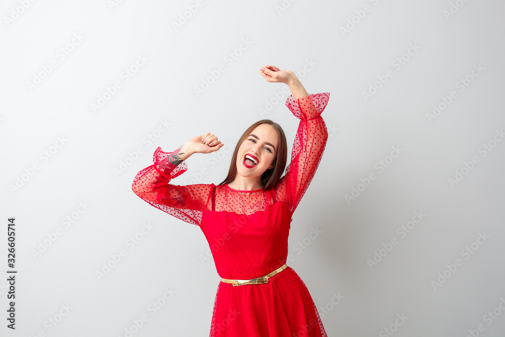 Happy young woman on light background