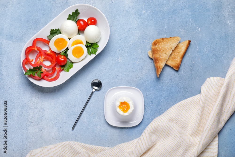 Fresh boiled eggs, vegetables and toasted bread on color background