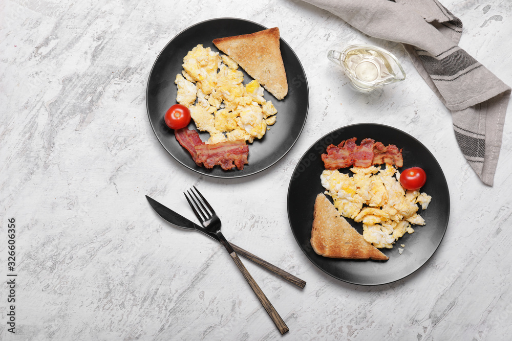 Tasty scrambled eggs with bacon and toasted bread on white background