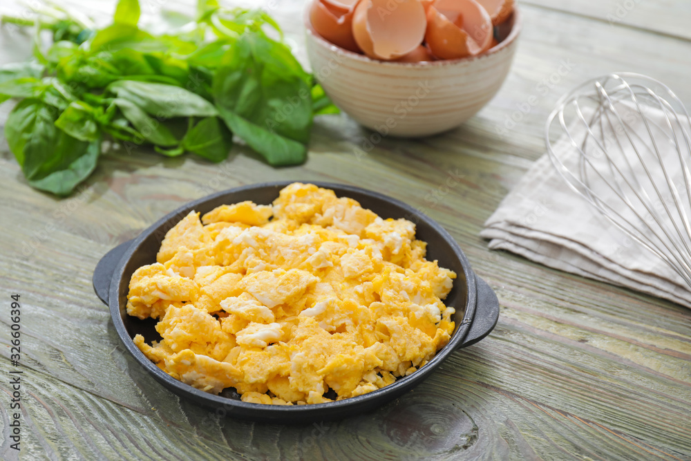 Frying pan with scrambled egg on table