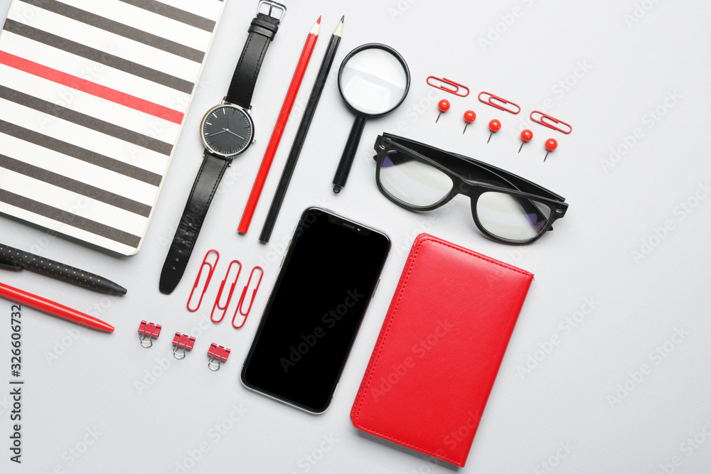 Set of school supplies with mobile phone on white background