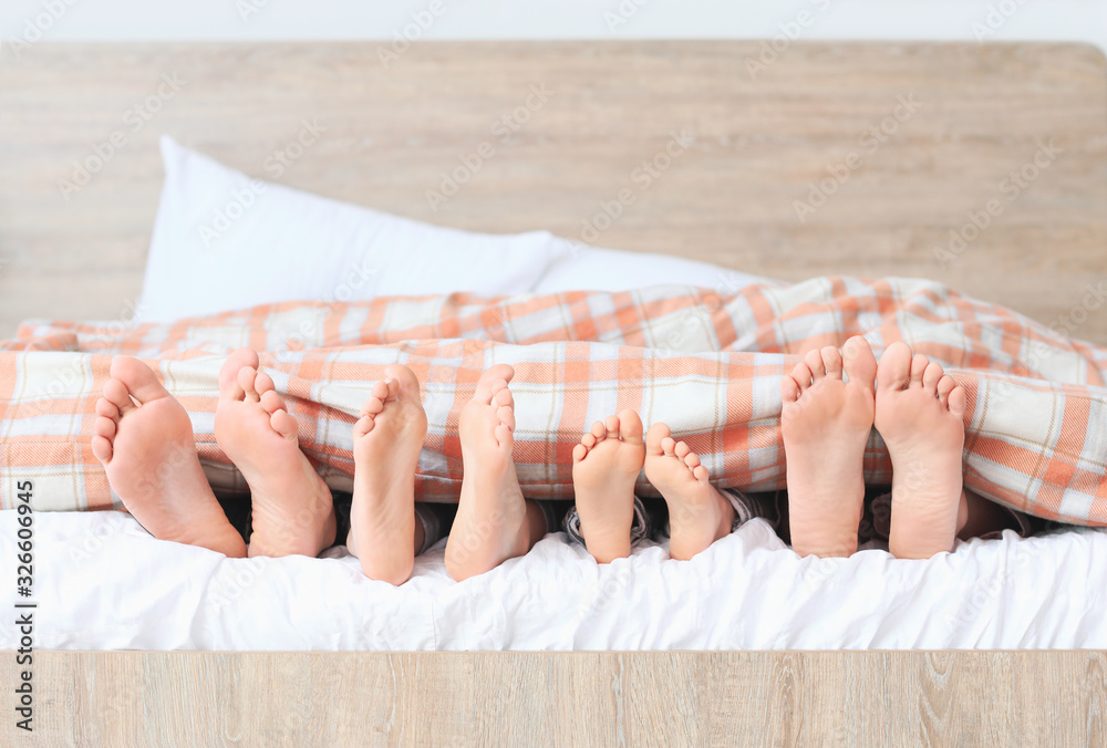 Family lying in bed at home