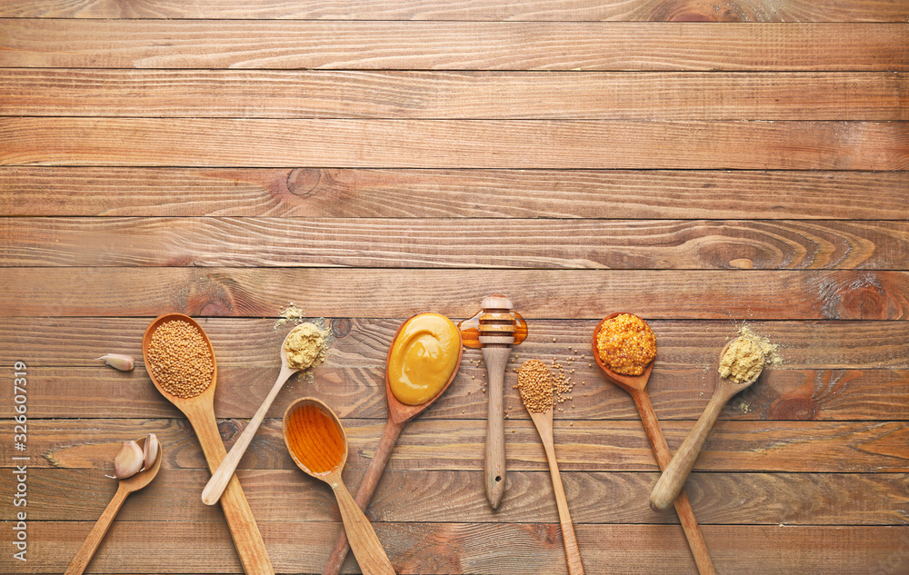 Tasty honey mustard sauce with ingredients on wooden background