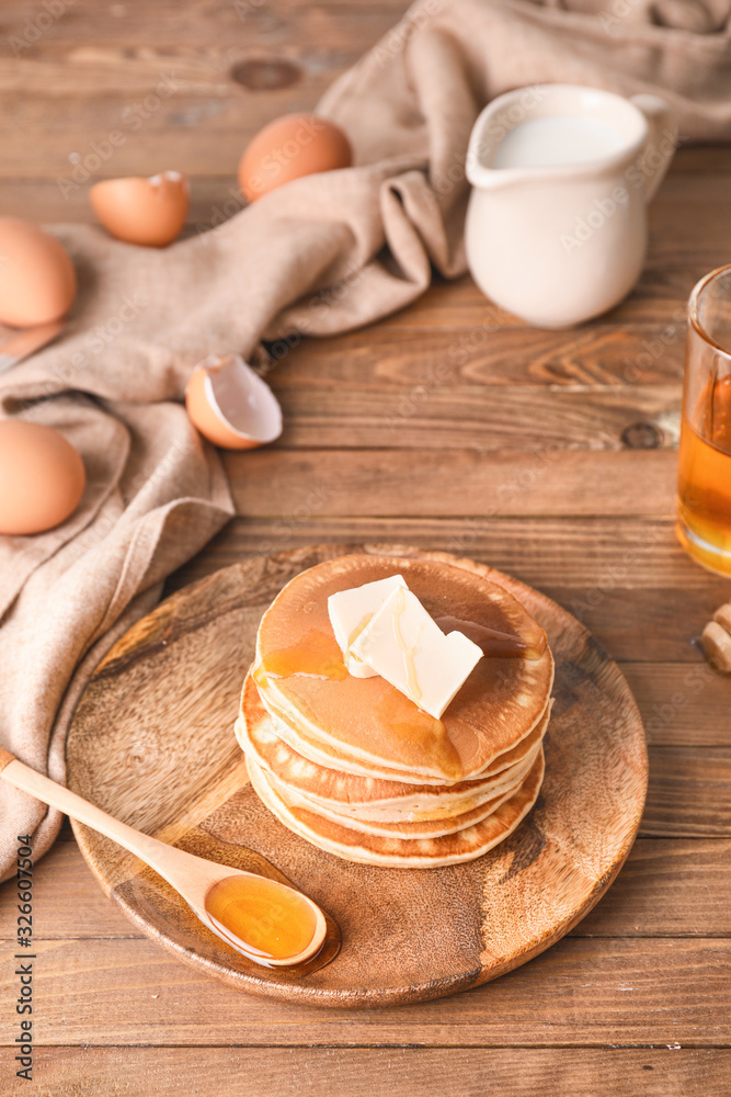 Tasty pancakes with honey and butter on plate