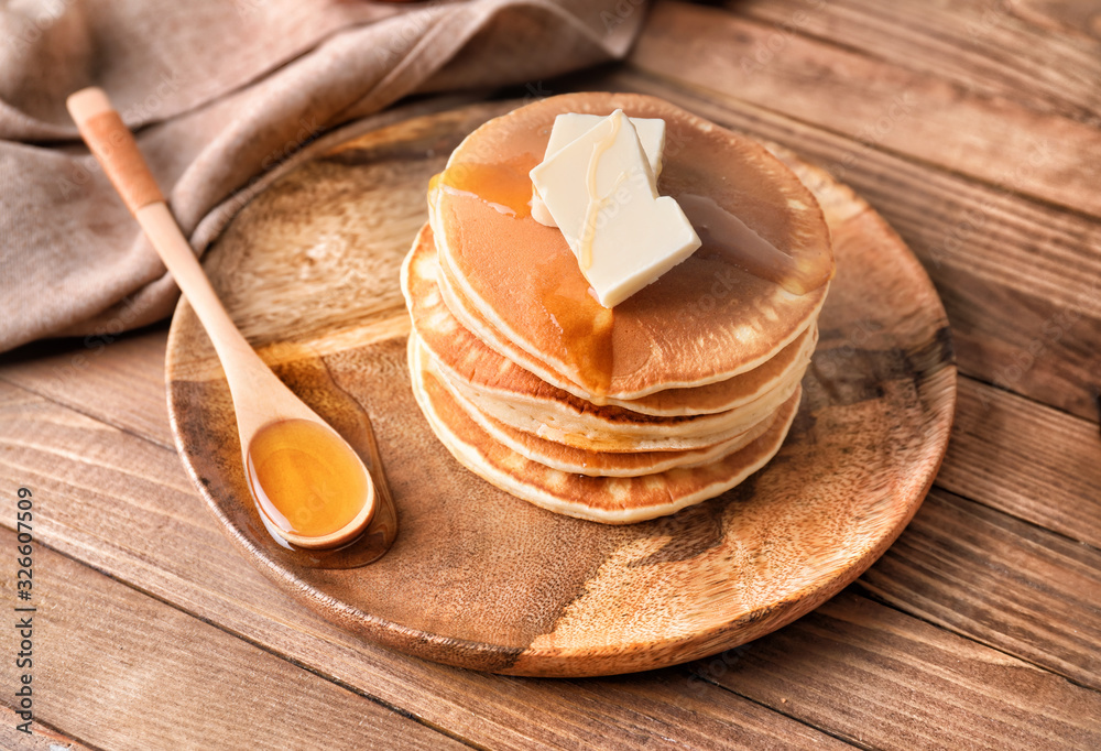 Tasty pancakes with honey and butter on plate