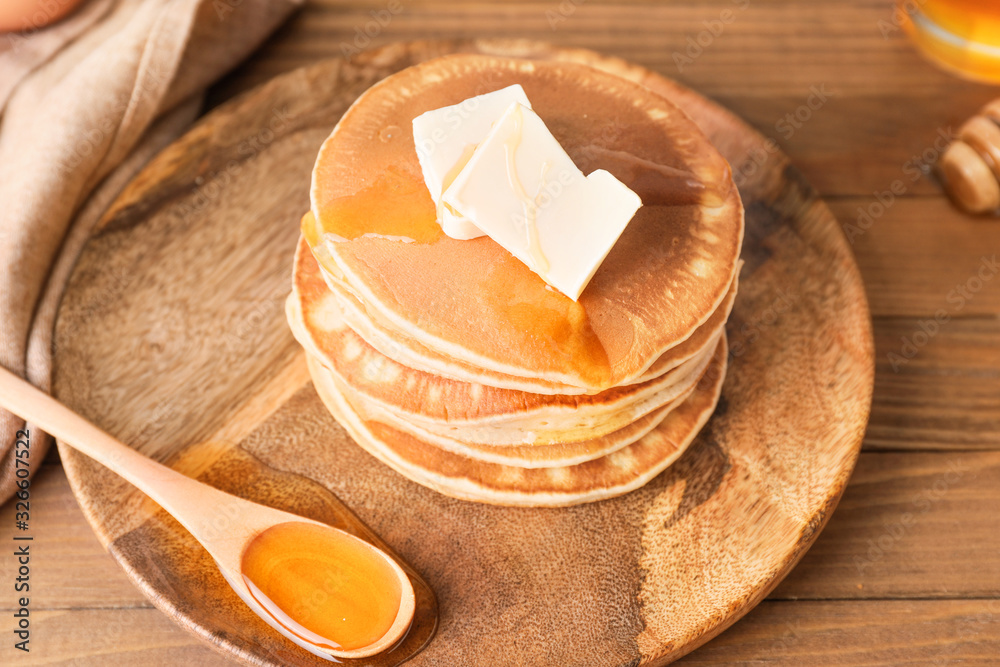 Tasty pancakes with honey and butter on plate