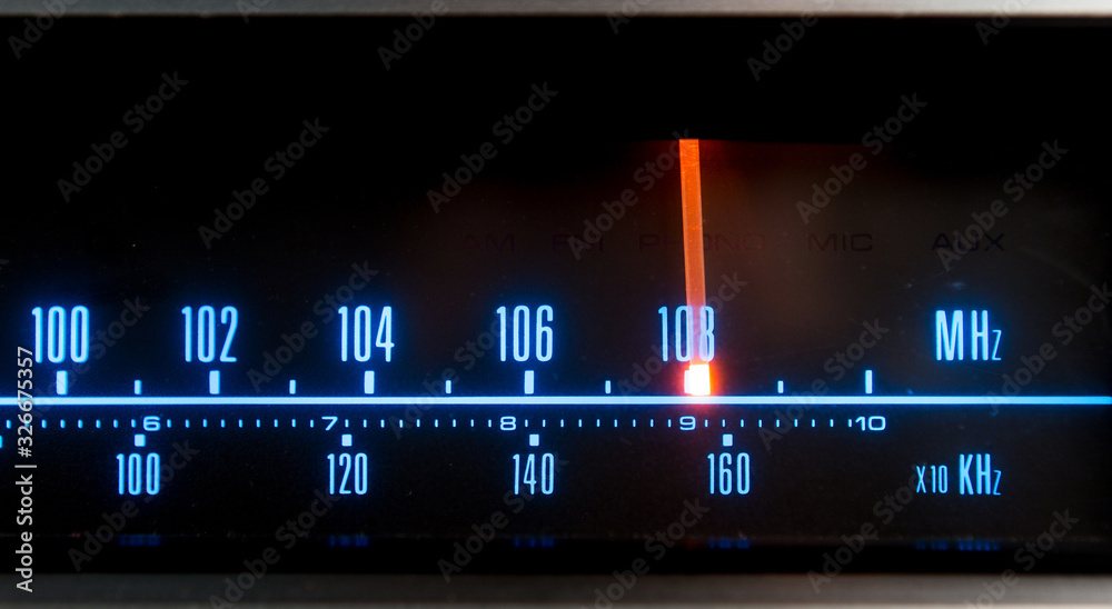 Classic radio tuner panel close-up. Black background