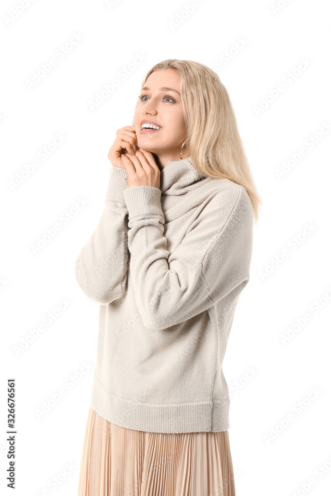 Beautiful young woman in warm sweater on white background