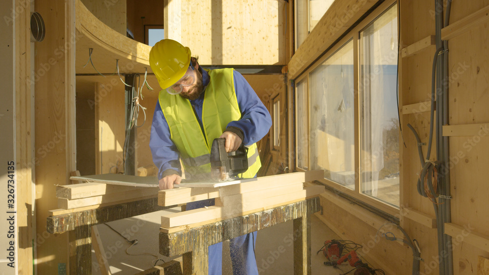 CLOSE UP: Worker building a hardwood house is trimming a gypsum wallboard.