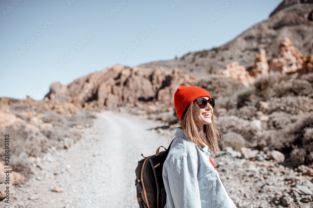 时尚无忧无虑的女人穿着牛仔裤，戴着红帽子，享受旅行的生活方式画像