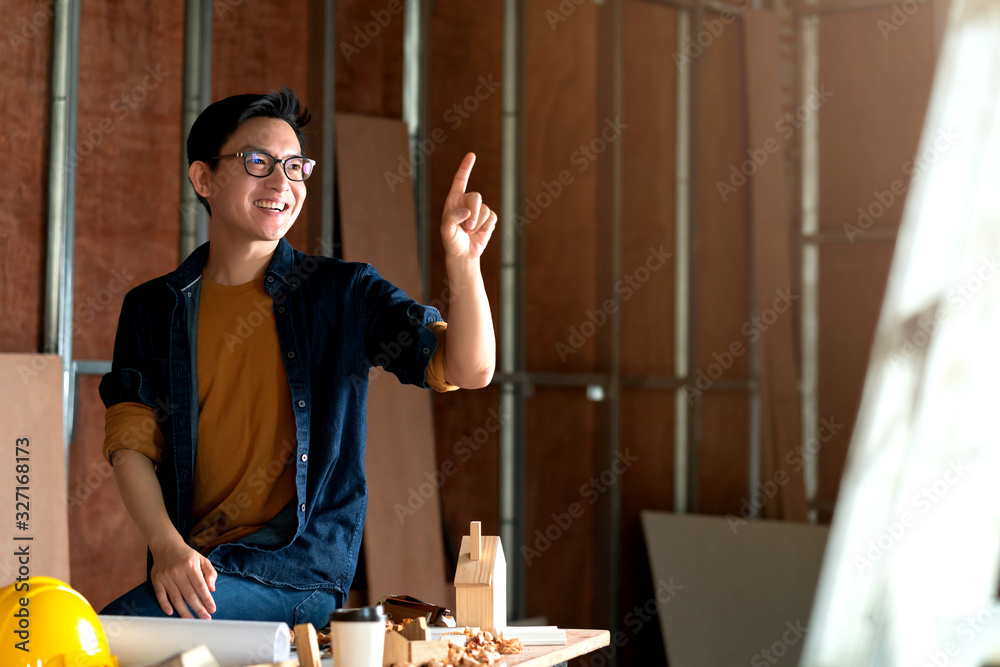 young asian carpenter hand draw in the air with copyspace for your text with background of house ren